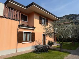 een huis met een tafel en stoelen in de tuin bij Casa Martinelli in Nago-Torbole