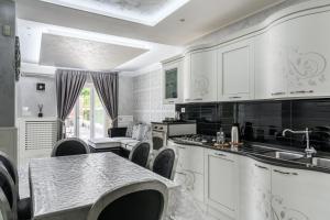 a kitchen with white cabinets and a table and chairs at Golden Garden in Naples