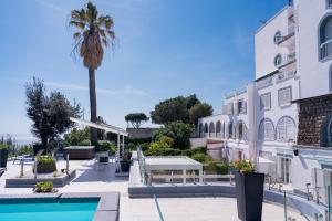 a hotel with a palm tree and a swimming pool at Golden Garden in Naples