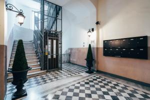 ボローニャにあるIndipendenza Loft City Centerの階段と市松模様の床のドアがあるロビー