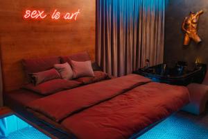 a bed with a sign that says sex is art at Story Rooms in Olomouc +15 photos