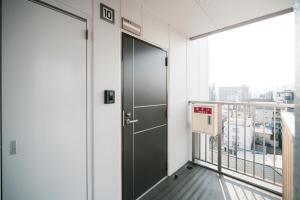 an elevator in an office building with a balcony at Chuan House Imazato in Osaka