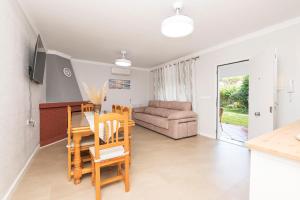 a living room with a table and chairs and a couch at Las Camelias in Chiclana de la Frontera