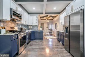 una grande cucina con armadi blu ed elettrodomestici in acciaio inossidabile di High level Where Sophistication meets Elegance a Baltimora