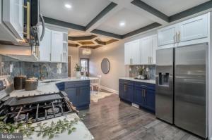 una cucina con armadi blu e frigorifero in acciaio inossidabile di High level Where Sophistication meets Elegance a Baltimora Altre 25 foto