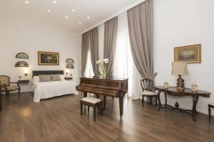 a bedroom with a piano and a bed and a desk at Luxe Madre de Dios in Sanlúcar de Barrameda +28 photos