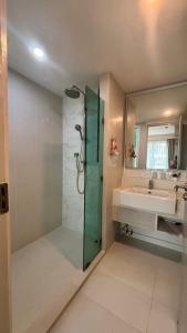 a bathroom with a shower and a sink and a mirror at seven sea F508 in Jomtien Beach