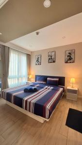 a bedroom with a large bed with a striped blanket at seven sea F508 in Jomtien Beach