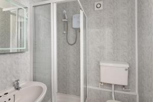 Un baño con ducha, inodoro y lavabo. en Big Pink House, en Mealsgate 40 fotos más