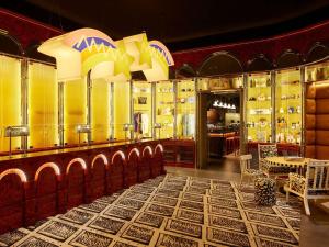 a restaurant with a bar with a lot of dishes at Mama Shelter Dubai in Dubai