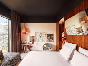 a bedroom with a large white bed and a table at Mama Shelter Dubai in Dubai +203 photos