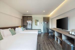 a hotel room with a bed and a flat screen tv at SureStay by Best Western Iconic Ari-Jatujak in Bangkok +79 photos