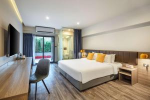 a hotel room with a bed and a chair at SureStay by Best Western Iconic Ari-Jatujak in Bangkok