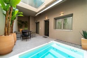 a swimming pool in the middle of a patio with a table at Iaspis Luxury Suites in Bendevís