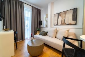 a living room with a white couch and a table at Iaspis Luxury Suites in Bendevís