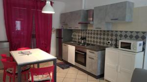 a small kitchen with a table and a microwave at La Casa di Tato in Montecarotto