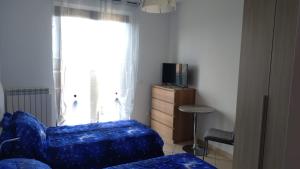 a living room with a blue couch and a television at La Casa di Tato in Montecarotto