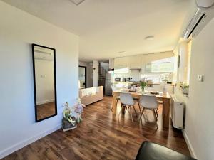 a kitchen and living room with a table and chairs at LULU Apartman in Sopron