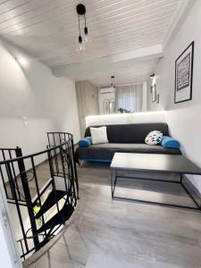 a living room with a couch and a chair in it at Burnelia Vacation Maisonette in Lefkímmi