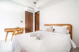 une chambre avec un lit blanc avec des serviettes dessus dans l'établissement Vinca Villa Bali, à Kerobokan 10 autres photos