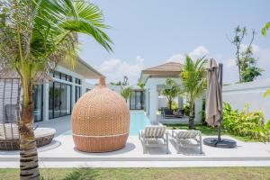 a view of a villa with a palm tree at Mouana Breeze Mai Khao 5-bedroom Pool Villa 9914 in Mai Khao Beach