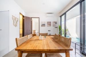 une salle à manger avec une table et des chaises en bois dans l'établissement Vinca Villa Bali, à Kerobokan
