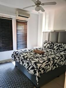 Un dormitorio con una cama con un edredón blanco y negro. en The Bridge Apartment, Unit 14, en St Lucia