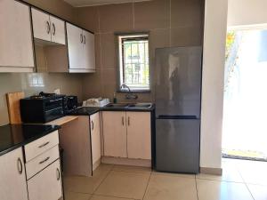 Una cocina con frigorífico de acero inoxidable y fregadero. en The Bridge Apartment, Unit 14, en St Lucia