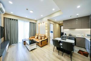a kitchen and living room with a couch and a table at VINHOMES GRAND PARK QUẬN 9 Căn hộ LUXURY MASTERI CENTRE POINT in Gò Công