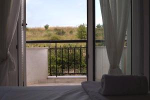 a bedroom with a bed and a view of a balcony at Stone Villa Nea Potidaia in Nea Potidaea