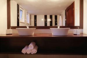 a bathroom with two sinks and towels on a counter at Stone Villa Nea Potidaia in Nea Potidaea +18 photos
