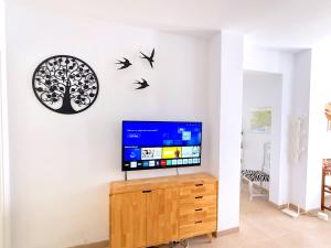 a living room with a tv and birds on a wall at Casa Alegre by Casasol in Nerja