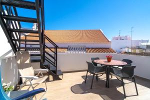 a patio with a table and chairs on a balcony at Casa Alegre by Casasol in Nerja