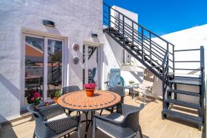 a patio with a table and chairs and a staircase at Casa Alegre by Casasol in Nerja