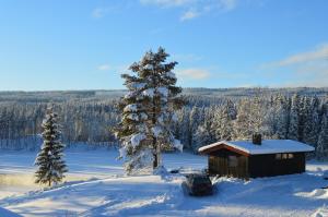 mały domek na śniegu z samochodem z przodu w obiekcie Trysil Hyttegrend w mieście Trysil