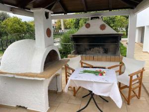a outdoor pizza oven with a table and a table and chairs at Casa de Alegria in Eretria +26 photos