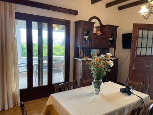 a dining room with a table with a vase of flowers on it at Casa de Alegria in Eretria