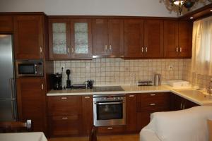 a kitchen with wooden cabinets and a stove top oven at Casa de Alegria in Eretria