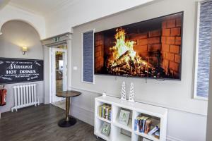 a fireplace in a living room with a fire in it at Majestic Hotel Eastbourne by Belvilla in Eastbourne +9 photos