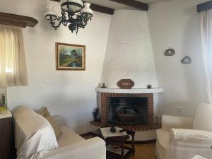 a living room with a fireplace and white walls at Casa de Alegria in Eretria