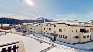 un grupo de edificios con nieve en los tejados en Abitaziun Glüna - Celerina, en Celerina