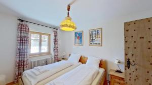 Dos camas en una habitación con ventana. en Abitaziun Glüna - Celerina, en Celerina