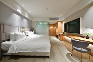 Postel nebo postele na pokoji v ubytování Mercure Qidong Downtown