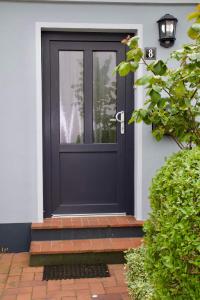 a black door with a window on a house at Fiete's Lüttes Huus in Husum +5 photos