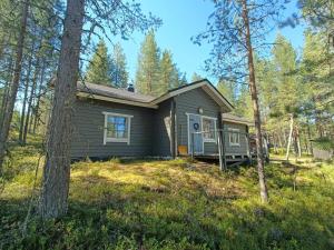 a small house with a porch in the woods at Pikkulammenkuja 1A in Syöte