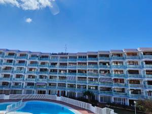 apartamentowiec z basenem przed nim w obiekcie Apartment in the heart of playa del ingles w mieście San Bartolomé