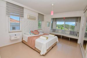 a bedroom with a bed and a bench and windows at Villa Ela, Royal Links,Sarigerme in Ortaca +55 photos