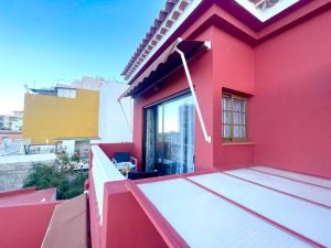 een rood huis met een raam op het dak bij Apartamentos Magdalena in Valle Gran Rey
