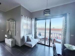 een woonkamer met een stoel en een groot raam bij Apartamentos Magdalena in Valle Gran Rey