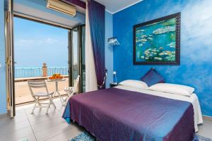 a bedroom with a bed and a balcony at Casa Mare Sea View in Giardini Naxos